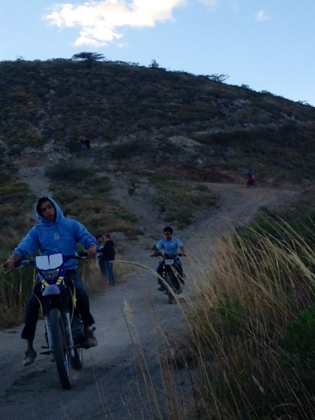 Motociclistas descienden desde la plataforma arqueológica donde hacen prácticas de motocross.